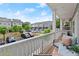 Cozy porch seating on a spacious balcony overlooking the parking area and neighboring homes under a bright blue sky at 2110 Prichard Park Dr, Kennesaw, GA 30144