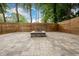 Stone paver patio with stone fire pit, surrounded by a stained wood fence at 2805 Pineland Ave, Atlanta, GA 30340