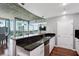 Kitchen with granite countertops, white cabinets, a black backsplash, and an attached seating area overlooking city views at 3324 Peachtree Rd # 1719, Atlanta, GA 30326