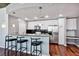Kitchen featuring white cabinets, a black backsplash, stainless steel appliances, a bar, and three bar stools at 3324 Peachtree Rd # 1719, Atlanta, GA 30326