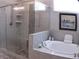 Bright bathroom showcases a glass shower, separate soaking tub, and tile surround at 3630 Deaton Trl, Buford, GA 30519