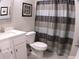 Neat bathroom featuring a shower with curtain, toilet, and single sink vanity at 3630 Deaton Trl, Buford, GA 30519
