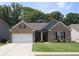 Charming brick home featuring a two-car garage, manicured lawn, and inviting front entrance at 3630 Deaton Trl, Buford, GA 30519