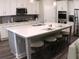Modern kitchen with a large island, stainless steel appliances, white cabinets, and hardwood floors for meal prep and dining at 3630 Deaton Trl, Buford, GA 30519