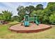 Community playground with slides and play structure surrounded by lush green trees and well-maintained grounds at 3630 Deaton Trl, Buford, GA 30519