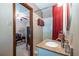 Clean and functional bathroom with granite vanity, shower with red curtain, and a door leading to a bedroom at 1602 Shamrock Se Trl, Smyrna, GA 30080