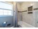 Bright bathroom featuring a tub with a shower curtain, tiled walls, and a window for natural light at 1602 Shamrock Se Trl, Smyrna, GA 30080