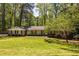 Well-maintained brick home with landscaped front yard and a mature tree, set amongst a wooded lot at 1602 Shamrock Se Trl, Smyrna, GA 30080