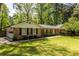 Charming brick home with attached garage and well-manicured front lawn and mature trees at 1602 Shamrock Se Trl, Smyrna, GA 30080