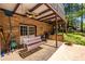 A covered patio with brick columns, a wooden swing, and a ceiling fan at 1602 Shamrock Se Trl, Smyrna, GA 30080