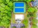 Overhead view featuring pool and tennis courts surrounded by lush greenery, with a quaint clubhouse at 1738 Honey Tree Pl, Hoschton, GA 30548