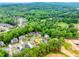 An aerial of a home with a lush green canopy and a neighborhood close by at 1738 Honey Tree Pl, Hoschton, GA 30548