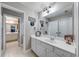 Bright bathroom showcasing a white vanity, a large mirror, and a view into an adjacent room at 1738 Honey Tree Pl, Hoschton, GA 30548