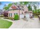 Brick home featuring a well-maintained lawn, beautiful landscaping, and a two-car garage at 1738 Honey Tree Pl, Hoschton, GA 30548