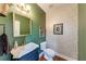 Stylish half bathroom featuring green walls, designer wall paper, gold accents, and elegant decor at 1738 Honey Tree Pl, Hoschton, GA 30548