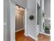 Hallway featuring a light fixture, hardwood floors, and white pillars at 1738 Honey Tree Pl, Hoschton, GA 30548