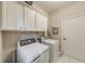 Bright laundry room with washer, dryer, and plenty of storage space at 1738 Honey Tree Pl, Hoschton, GA 30548