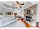 Comfortable living room featuring a stone fireplace, open to kitchen, and hardwood floors at 1738 Honey Tree Pl, Hoschton, GA 30548