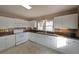 Bright kitchen with white cabinets, stainless appliances, dark countertops, and tile backsplash at 2651 Old Lost Mountain Rd, Powder Springs, GA 30127
