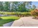 Beautiful backyard featuring lush greenery, manicured shrubs, and a well-maintained concrete patio at 5004 Gunnison Trce, Suwanee, GA 30024