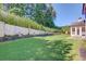 Expansive backyard featuring lush green lawn and decorative statues along retaining wall at 5004 Gunnison Trce, Suwanee, GA 30024