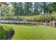 Lush backyard featuring a retaining wall adorned with statues, creating a serene outdoor oasis at 5004 Gunnison Trce, Suwanee, GA 30024