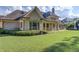 Well-manicured backyard with a stone house and a lush green lawn at 5004 Gunnison Trce, Suwanee, GA 30024