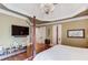 Well-appointed bedroom with a tray ceiling, modern entertainment center, and elegant decor at 5004 Gunnison Trce, Suwanee, GA 30024