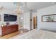 Bedroom showcasing chandelier, tray ceiling, hardwood floors and a large window at 5004 Gunnison Trce, Suwanee, GA 30024