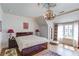 Bedroom with a wooden bed frame, a large window, and hardwood floors at 5004 Gunnison Trce, Suwanee, GA 30024