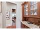 Butler's pantry boasting granite countertops, hardwood floors, and classic wooden cabinetry, enhancing functionality at 5004 Gunnison Trce, Suwanee, GA 30024