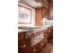 This gourmet kitchen features a stainless steel stove and oven combo with dark wood cabinetry at 5004 Gunnison Trce, Suwanee, GA 30024