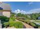 Professionally landscaped yard with walkway and green shrubs in front of luxury home at 5004 Gunnison Trce, Suwanee, GA 30024