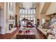 Spacious living room with high ceilings, chandelier, fireplace, and large windows providing ample natural light at 5004 Gunnison Trce, Suwanee, GA 30024