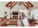 Well-lit living room featuring wooden beams, a leather sofa, detailed decor and a large screen television at 5004 Gunnison Trce, Suwanee, GA 30024