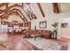 Open concept living room with vaulted ceiling, wood beams, leather furniture, and chandelier lighting at 5004 Gunnison Trce, Suwanee, GA 30024