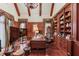 Well-appointed office featuring wood-paneled walls, beamed ceiling, and custom shelving, creating an inspiring workspace at 5004 Gunnison Trce, Suwanee, GA 30024