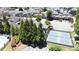 Aerial view highlights community tennis courts and pool along with an overview of the surrounding neighborhood and mature trees at 690 Stickley Oak Way, Woodstock, GA 30189