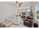 Cozy living room with ample seating, a ceiling fan, and an office area at 690 Stickley Oak Way, Woodstock, GA 30189