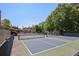 Well-maintained tennis courts surrounded by mature trees provide a private space for residents of the community to gather and play at 690 Stickley Oak Way, Woodstock, GA 30189