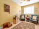 Cozy bedroom featuring two blue armchairs, a decorative rug, and a charming dollhouse display at 200 Suffolk Way, Mcdonough, GA 30252