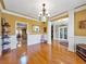 Spacious dining room with hardwood floors, wainscoting, chandelier, and access to other rooms at 200 Suffolk Way, Mcdonough, GA 30252