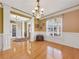 Elegant dining room featuring hardwood floors, wainscoting, chandelier, and a large window at 200 Suffolk Way, Mcdonough, GA 30252