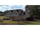 An elevated view of a two-story home showing landscaping and mature trees at 200 Suffolk Way, Mcdonough, GA 30252