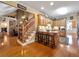 Open kitchen with wood cabinets, island seating and hardwood floors throughout, adjacent to a living room with fireplace at 200 Suffolk Way, Mcdonough, GA 30252