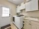 Functional laundry room with washer, dryer, sink, cabinets, and access to the outside at 200 Suffolk Way, Mcdonough, GA 30252