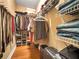 Organized walk-in closet with hanging clothes, folded jeans, belts and shoe shelves for ample storage at 200 Suffolk Way, Mcdonough, GA 30252