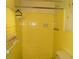 Bathroom with yellow tile, including a shower, toilet, and storage at 5542 Joeclay Dr, Stone Mountain, GA 30088