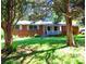 Quaint brick home with a cozy front porch surrounded by lush green lawn and mature trees at 5542 Joeclay Dr, Stone Mountain, GA 30088