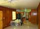 Open-concept living room leading to kitchen with wood paneling and tile floors at 5542 Joeclay Dr, Stone Mountain, GA 30088